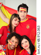 A group of friends supporting the Spanish football team. Стоковое фото, агентство Ingram Publishing / Фотобанк Лори