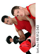 muscular fellow lifting weight and guy with boxing gloves. Стоковое фото, агентство Ingram Publishing / Фотобанк Лори