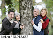 Two generations stood against tree. Стоковое фото, агентство Ingram Publishing / Фотобанк Лори