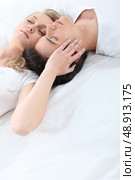 Affectionate young couple laying in bed. Стоковое фото, агентство Ingram Publishing / Фотобанк Лори