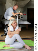 Senior couple doing gymnastics in the room. Стоковое фото, агентство Ingram Publishing / Фотобанк Лори