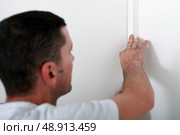 Man concealing wiring. Стоковое фото, агентство Ingram Publishing / Фотобанк Лори