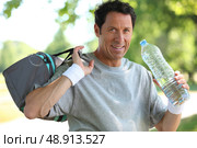 50 years old man drinking man after he did sport. Стоковое фото, агентство Ingram Publishing / Фотобанк Лори
