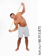 Man exercising with a wooden stick. Стоковое фото, агентство Ingram Publishing / Фотобанк Лори