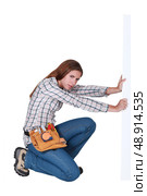 Woman laboriously holding up a blank sign. Стоковое фото, агентство Ingram Publishing / Фотобанк Лори