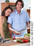 Couple in kitchen with cookbook. Стоковое фото, агентство Ingram Publishing / Фотобанк Лори