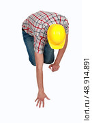 Tradesperson reaching forfallen object. Стоковое фото, агентство Ingram Publishing / Фотобанк Лори