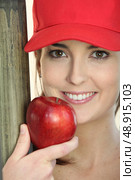 woman wearing a cap and eating an apple. Стоковое фото, агентство Ingram Publishing / Фотобанк Лори