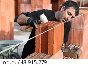 Man making sure wall is straight. Стоковое фото, агентство Ingram Publishing / Фотобанк Лори