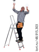 Electrocuted man changing a light bulb. Стоковое фото, агентство Ingram Publishing / Фотобанк Лори