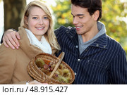 Couple collecting chestnuts in the woods. Стоковое фото, агентство Ingram Publishing / Фотобанк Лори