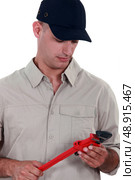 Handyman holding a vernier caliper. Стоковое фото, агентство Ingram Publishing / Фотобанк Лори