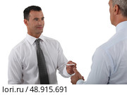 Man handing over his business card to a potential client. Стоковое фото, агентство Ingram Publishing / Фотобанк Лори