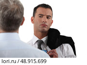 Man looking suspiciously at his colleague. Стоковое фото, агентство Ingram Publishing / Фотобанк Лори
