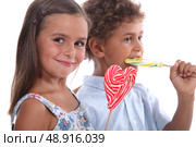 two skittish kids with lollypops. Стоковое фото, агентство Ingram Publishing / Фотобанк Лори