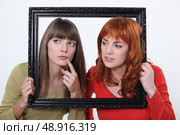 girls behind a wooden frame. Стоковое фото, агентство Ingram Publishing / Фотобанк Лори