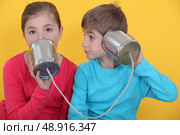 Children using cans as phone. Стоковое фото, агентство Ingram Publishing / Фотобанк Лори