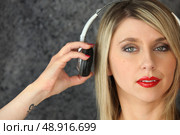 Woman putting on a pair of headphones. Стоковое фото, агентство Ingram Publishing / Фотобанк Лори