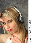 Woman wearing headphones making youthful gesture. Стоковое фото, агентство Ingram Publishing / Фотобанк Лори