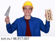 craftsman holding a brick and a trowel. Стоковое фото, агентство Ingram Publishing / Фотобанк Лори