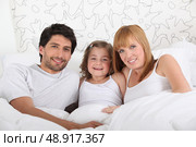 Family in bed together on Sunday morning. Стоковое фото, агентство Ingram Publishing / Фотобанк Лори