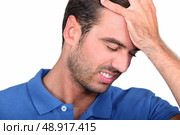 a 35 years old man taking his head with his hand, his face expresses failure. Стоковое фото, агентство Ingram Publishing / Фотобанк Лори