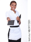black waitress giving a menu. Стоковое фото, агентство Ingram Publishing / Фотобанк Лори