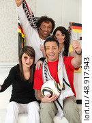 Two couples supporting German football. Стоковое фото, агентство Ingram Publishing / Фотобанк Лори