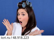 cute brunette in bathrobe with hair curlers against blue background. Стоковое фото, агентство Ingram Publishing / Фотобанк Лори