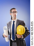 Young architect with drawings and hardhat. Стоковое фото, агентство Ingram Publishing / Фотобанк Лори