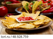 plate of nachos with salsa on wooden table. Стоковое фото, агентство Ingram Publishing / Фотобанк Лори
