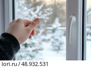 Hand on New plastic PVC window with white metal frame installed at modern house. View of blurred winter snow, blue sky. Advertising. Typical installation of glazing windows with uPVC window frames. Стоковое AI-изображение, AI-художник Марина Демидюк / Фотобанк Лори