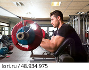 biceps preacher bench arm curl workout man at fitness gym. Стоковое фото, агентство Ingram Publishing / Фотобанк Лори