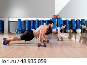 Dumbbells push-ups pushups couple at fitness gym workout. Стоковое фото, агентство Ingram Publishing / Фотобанк Лори