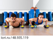 Dumbbells push-ups pushups couple at fitness gym workout. Стоковое фото, агентство Ingram Publishing / Фотобанк Лори