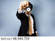 Young man holding a clock. Стоковое фото, агентство Ingram Publishing / Фотобанк Лори