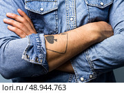 Young man with tattoo is crossing his arms. Стоковое фото, агентство Ingram Publishing / Фотобанк Лори