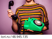 Young woman answering old rotary phone. Стоковое фото, агентство Ingram Publishing / Фотобанк Лори