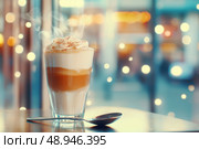 A latte macchiato in a tall glass sits elegantly with espresso and cream layers gleaming, paired with a silver spoon. It exudes warmth against a blurred, pastel-hued café backdrop, perfect for coffee enthusiasts. Стоковое AI-изображение, AI-художник Nart / Фотобанк Лори
