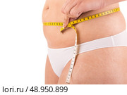 Fat woman measuring her body. Стоковое фото, агентство Ingram Publishing / Фотобанк Лори