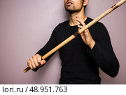 Young man ready for a fight with sticks. Стоковое фото, агентство Ingram Publishing / Фотобанк Лори