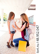 Mother saying goodbye to her daughter at shool. Стоковое фото, агентство Ingram Publishing / Фотобанк Лори