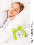 Beautiful woman sleeping with alarmclock on the bed . Стоковое фото, агентство Ingram Publishing / Фотобанк Лори