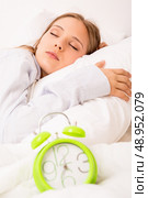 Beautiful woman sleeping with alarmclock on the bed . Стоковое фото, агентство Ingram Publishing / Фотобанк Лори