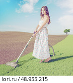 Young woman cleaning natural green grass  in wild  landscape. Creative concept photo combinated. Стоковое фото, агентство Ingram Publishing / Фотобанк Лори