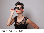 Young fashionable woman in round sunglasses posing in guipure dress. Red lips. Updo, twisted high bun. top knot. Стоковое фото, агентство Ingram Publishing / Фотобанк Лори