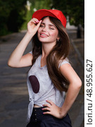 beautiful smiling teen model on street. red cap, grey t-shirt, dark blue shorts. Стоковое фото, агентство Ingram Publishing / Фотобанк Лори