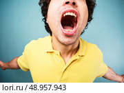 Young man is screaming with his mouth wide open. Стоковое фото, агентство Ingram Publishing / Фотобанк Лори
