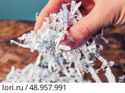 Hand is holding a bunch of shredded paper. Стоковое фото, агентство Ingram Publishing / Фотобанк Лори