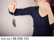 A squeamish and disgusted woman is holding a dead mouse by it’s tail. Стоковое фото, агентство Ingram Publishing / Фотобанк Лори